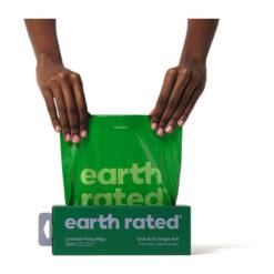Handen trekken een lavendel hondenpoepzakje uit de Earth Rated poepzakjesdoos