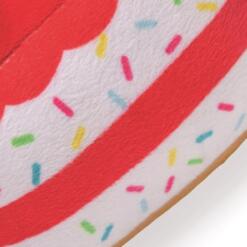 Detail van de rood witte lagen met gekleurde sprinkels op de pluche taart